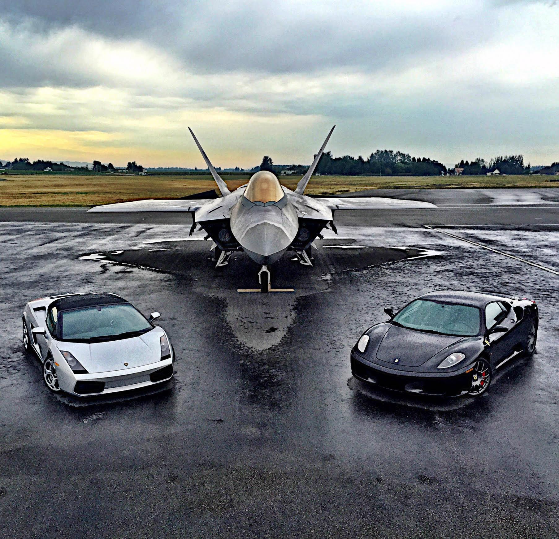Fighter jet in the middle of two exotic cars